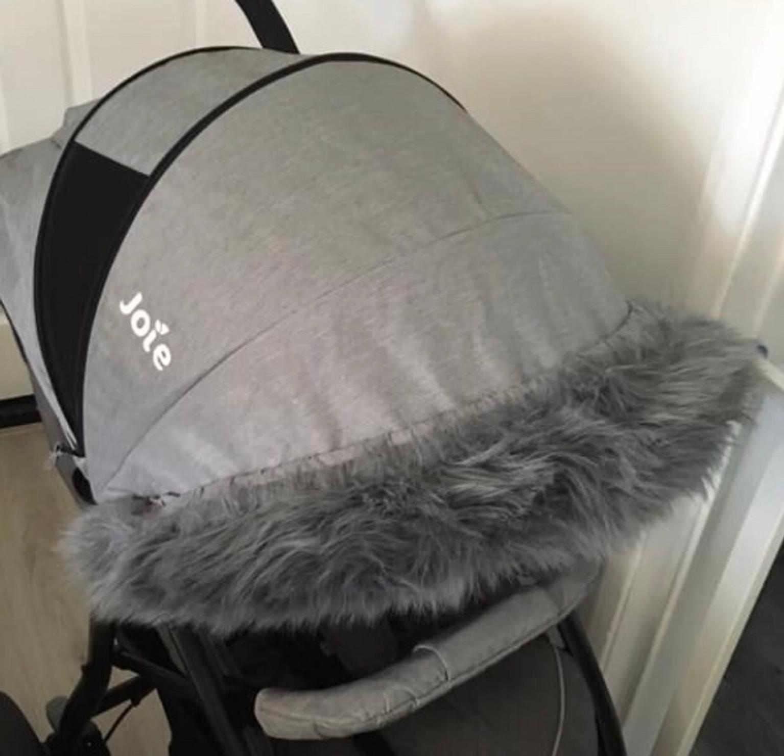 grey pram with fur hood